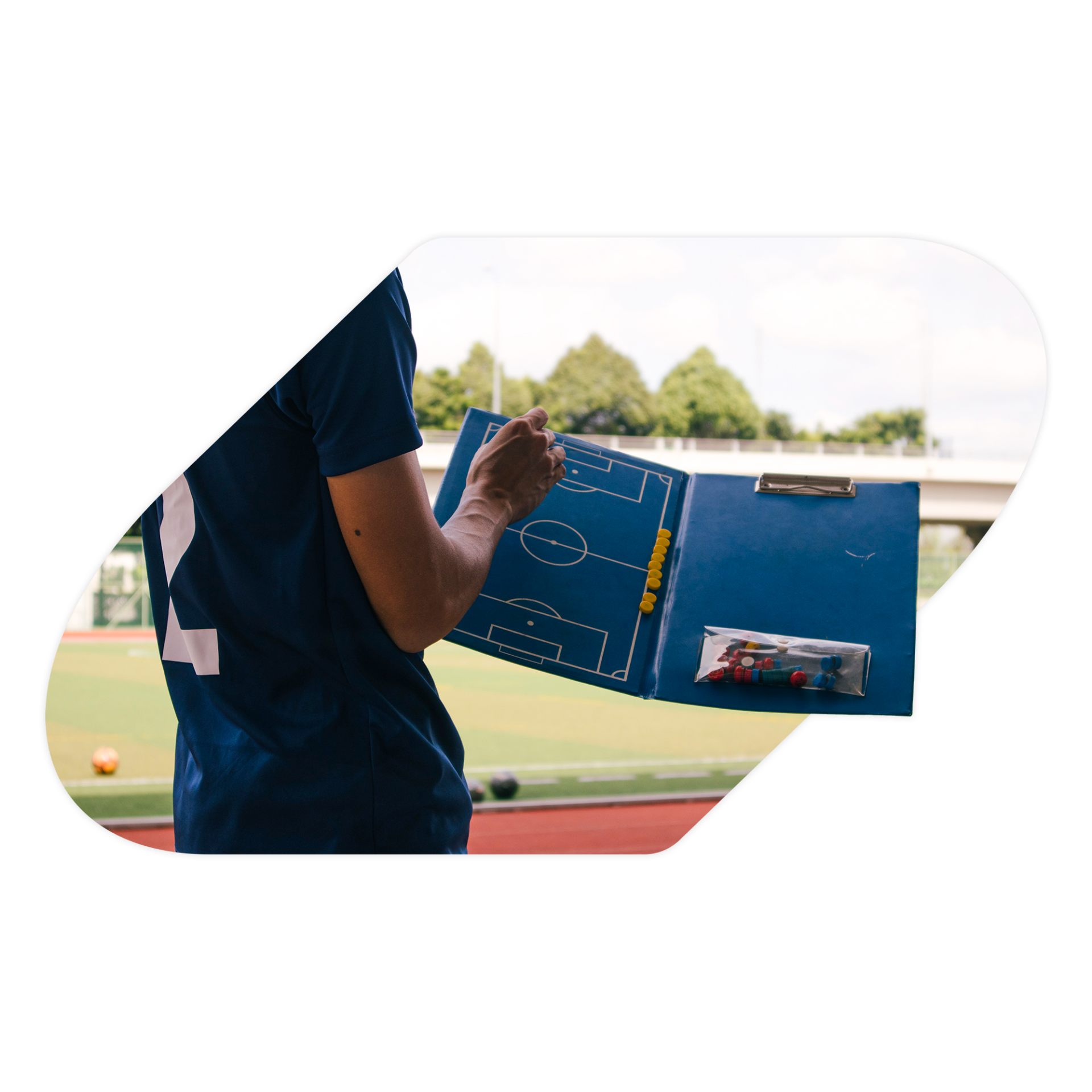 Soccer player planning a play on a magnetic play folder.