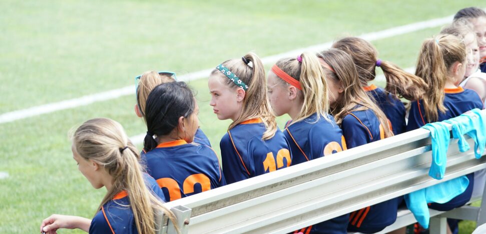 Girls athletic team sitting on bench